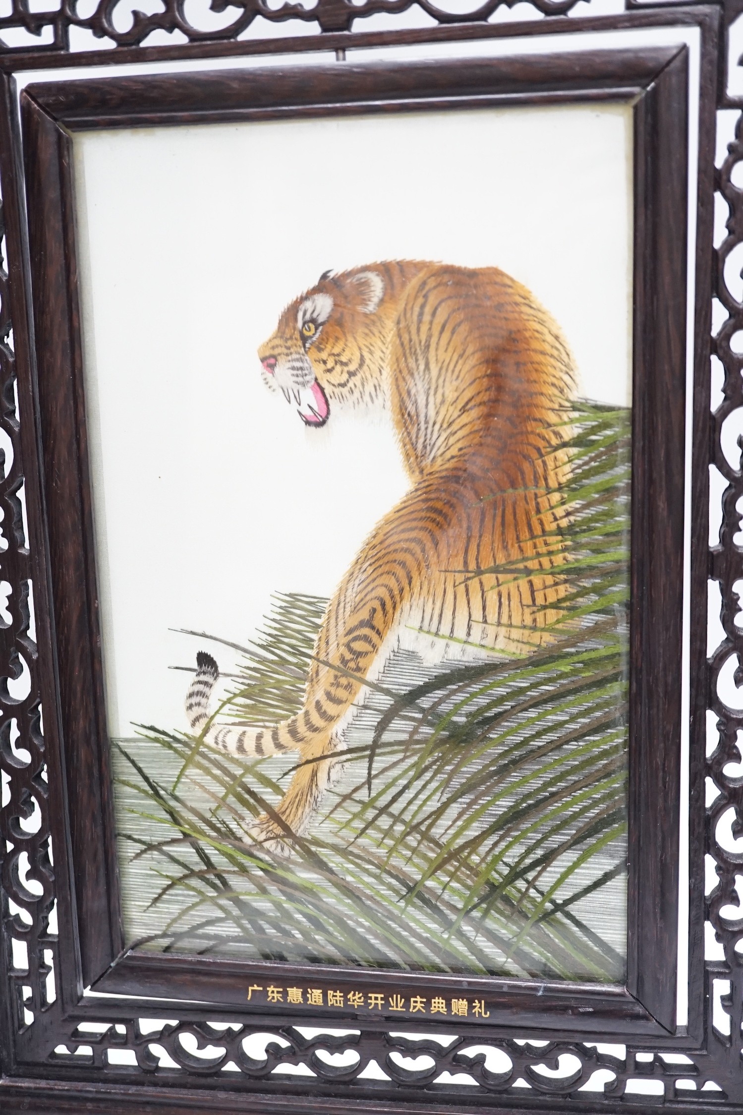 A Chinese reversible silk embroidered panel of a tiger in a revolving screen and hardwood carved frame, 45cms high